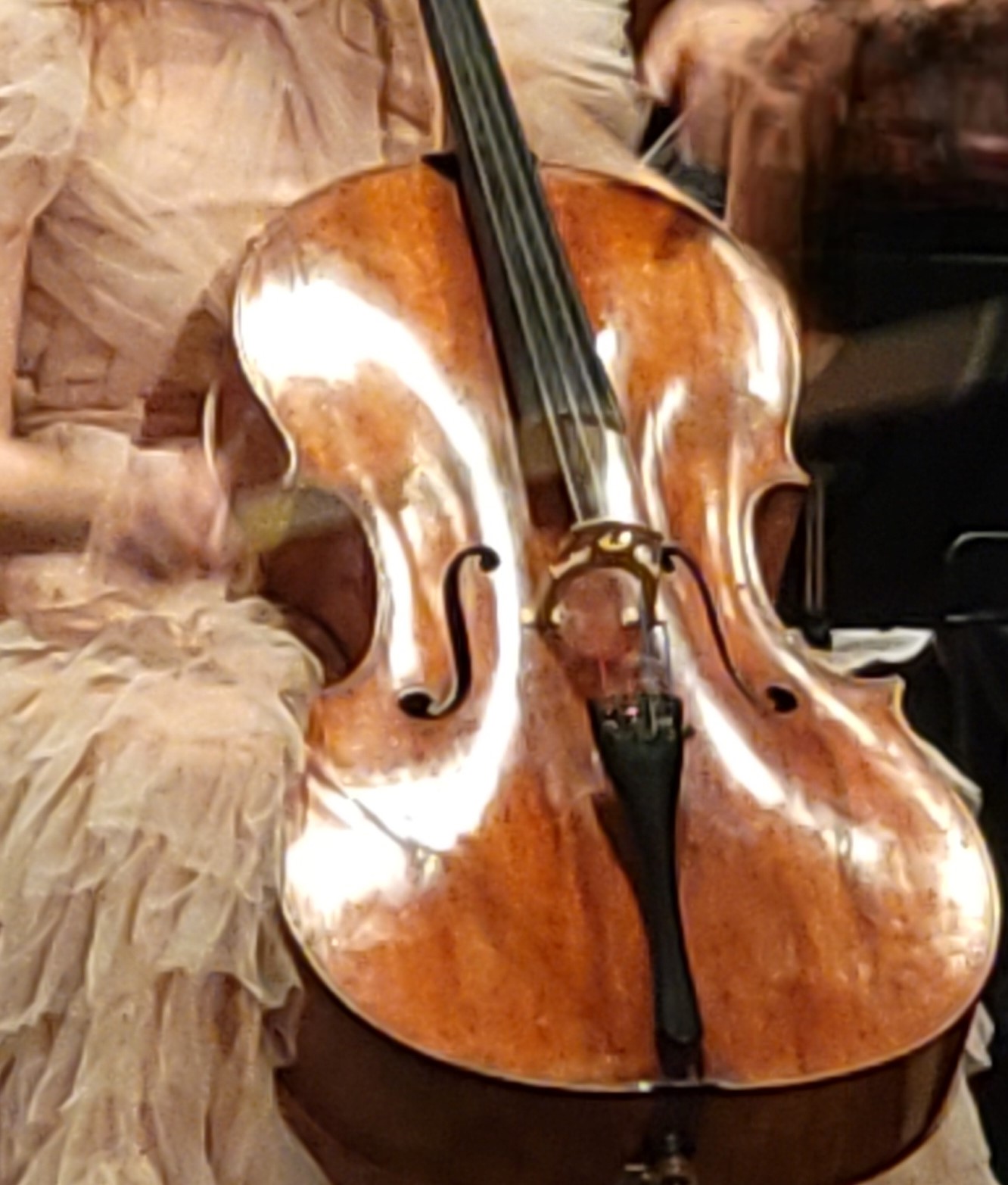 A cellist's hands blur creating music, much like our prayers reaching Heaven.